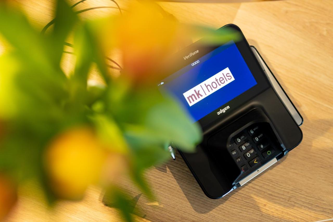 Mk Hotel Tirana Rinas Luaran gambar A mobile phone with the MK1Hotels logo on the screen